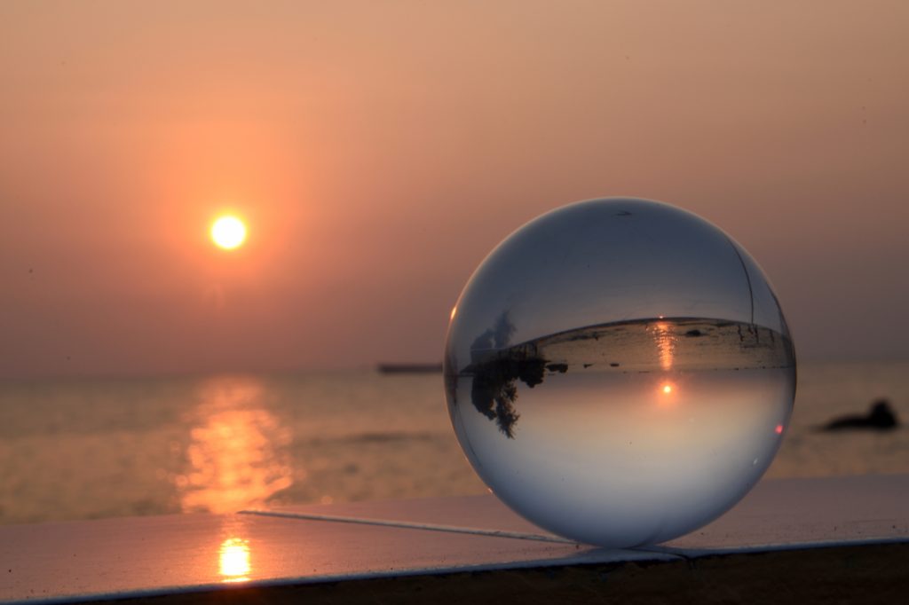 Glaskugel mit Sonnenuntergang im Hintergrund